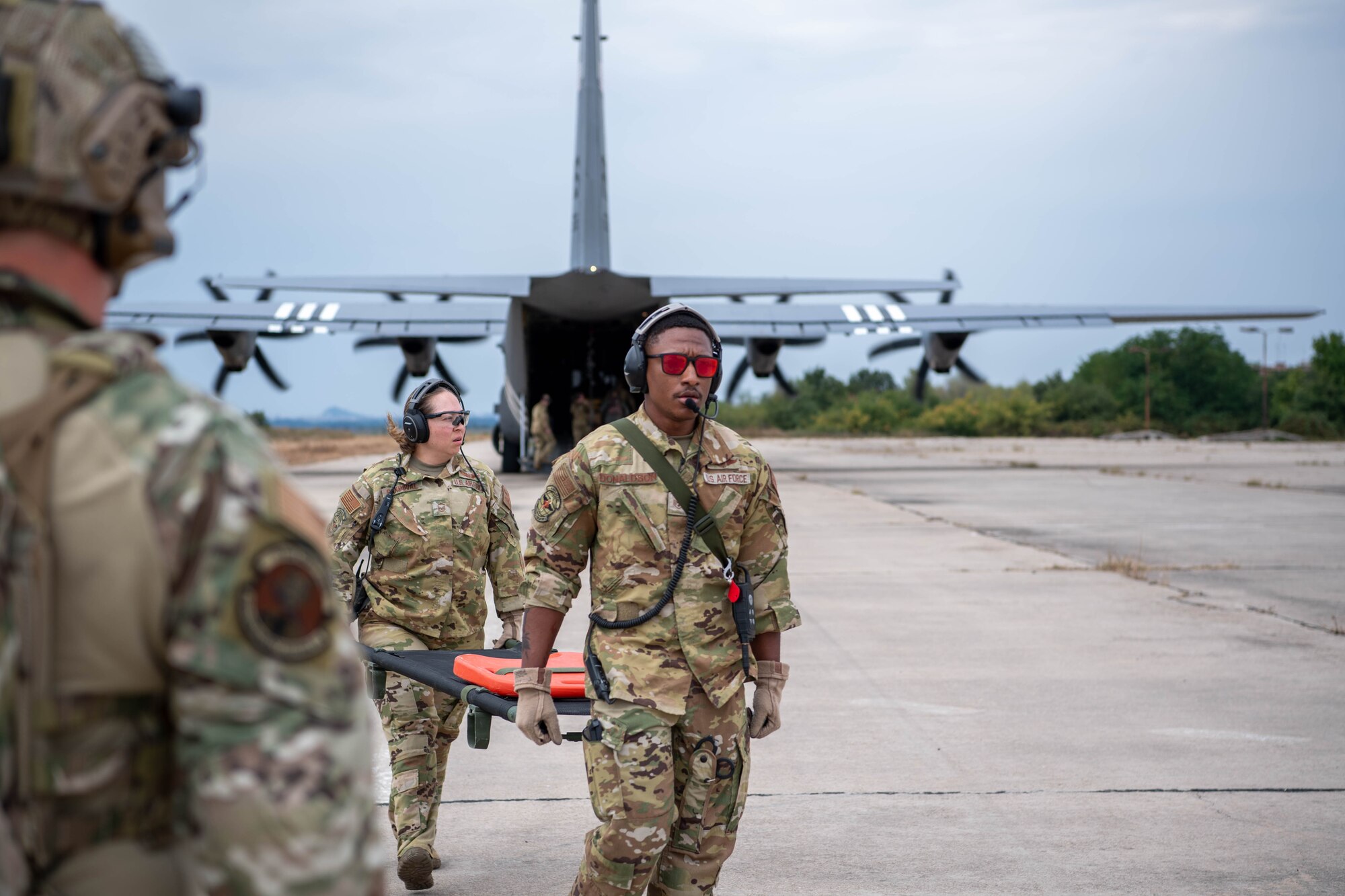 U.S. Air Force Master Sgt. Claudia I. Sandoval, 86th Aeromedical Evacuation Squadron superintendent, center, and Staff Sgt. Lewis C. Donaldson, 86th AES aeromedical evacuation technician, right, off-load equipment at Cheshnegirovo Air Base, Bulgaria, Aug. 10, 2023.