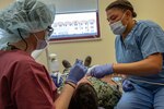 U.S. Air Force Maj. Hillary Homburg (left) and Airman Basic Kalysta Keaton, an orthodontist and dental technician, respectively, assigned to the 130th Medical Group, work on a patient during their Medical Facility Annual Training (MFAT) on July 20, 2023, at Sigonella Naval Air Station, Italy. MFAT allows National Guard medical personnel to receive real-world experience in a military medical facility. (U.S. Air National Guard photo by 2d Lt. De-Juan Haley)