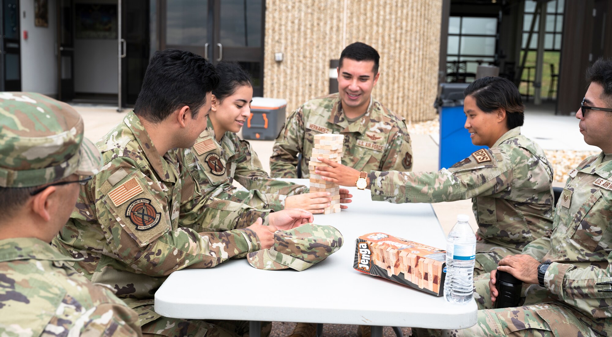 People in military uniforms sitting at a table playing board games.