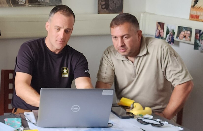 Ken Gregoire (on right) is wrapping up a six-month Army Expeditionary Civilian Workforce program tour at the Coleman Army Prepositioned Stocks-2 worksite in Mannheim, Germany, as a human resources specialist with Army Field Support Battalion-Mannheim, 405th Army Field Support Brigade. Pictured here, Gregoire discusses daily personnel status reporting with a fellow AECW employee at AFSBn-Mannheim. (U.S. Army courtesy photo)