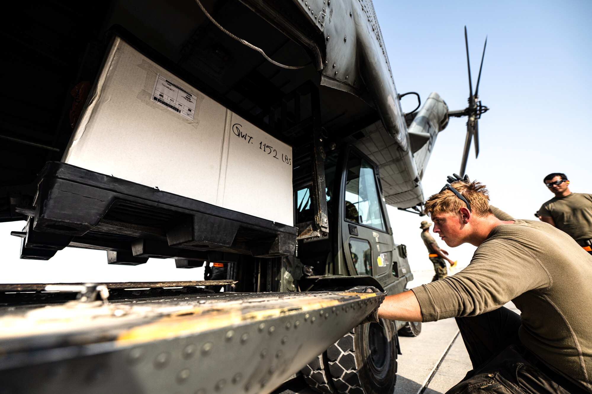 Photo of person loading cargo onto an aircraft