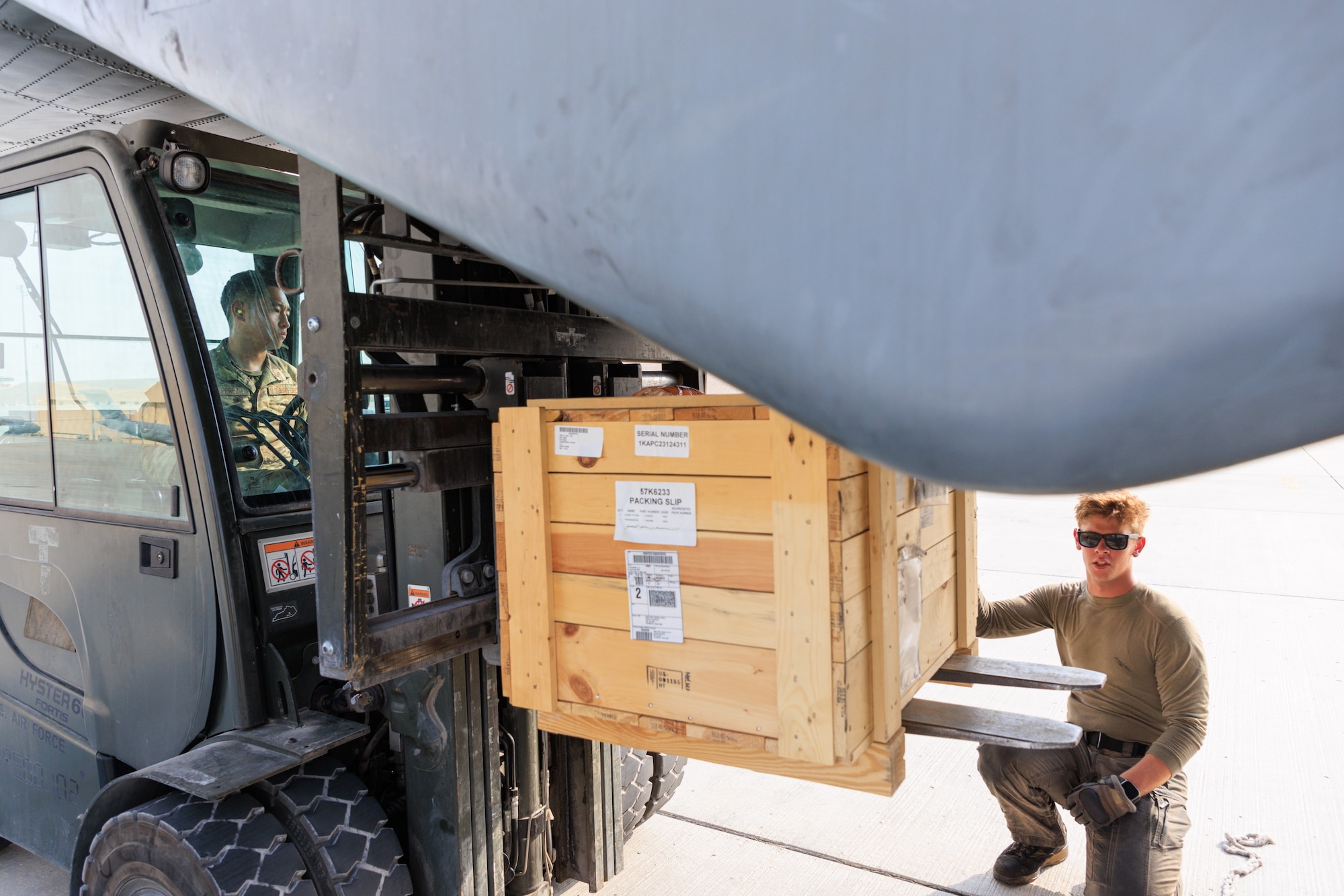 Photo of person operating a forklift on a flight line