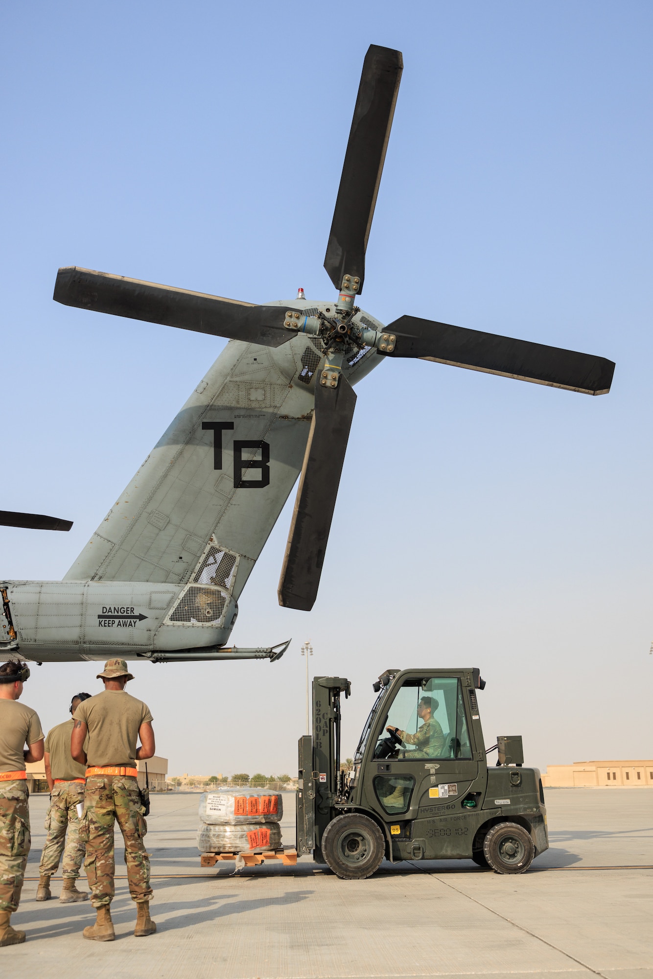 Photo of person operating a forklift on a flight line