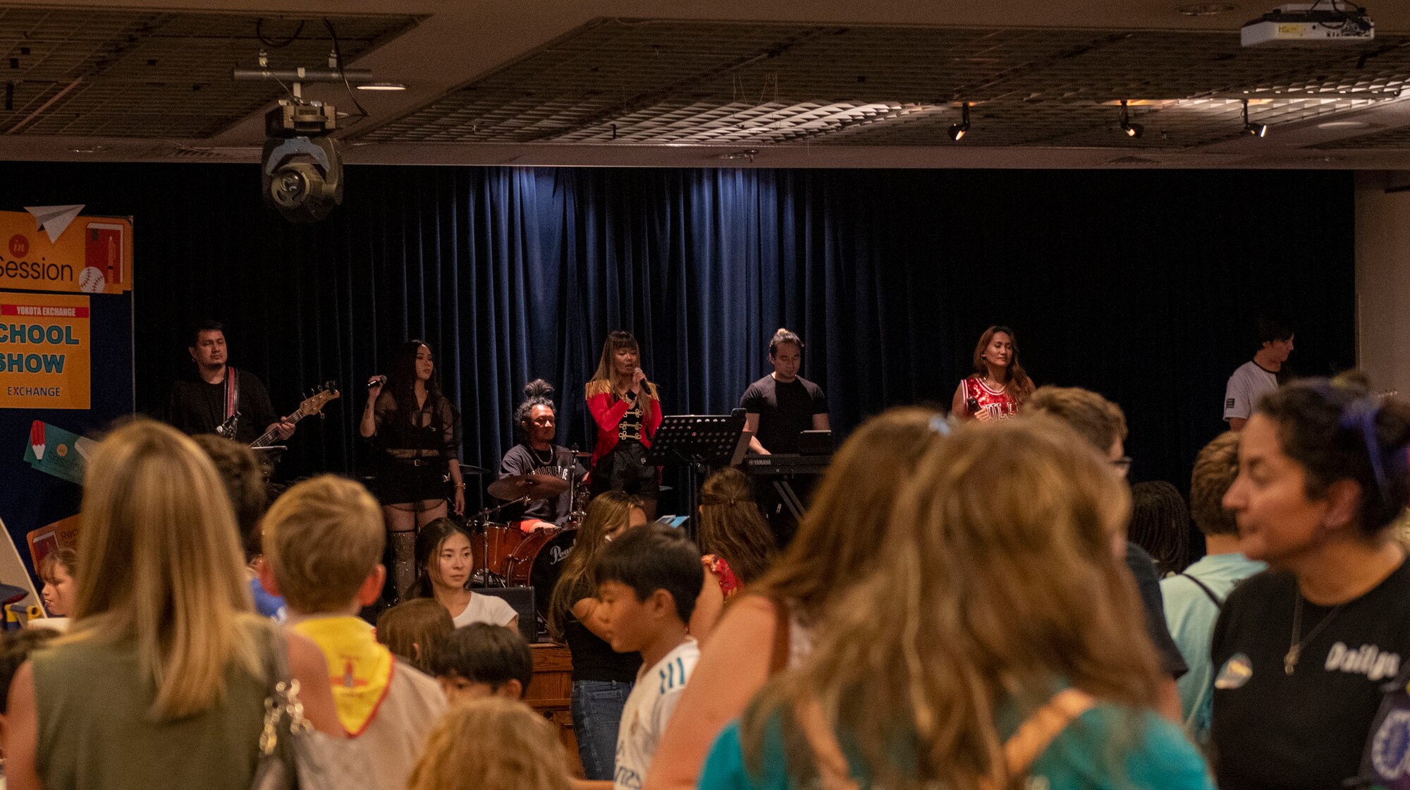 A band performs on stage in front of many people.