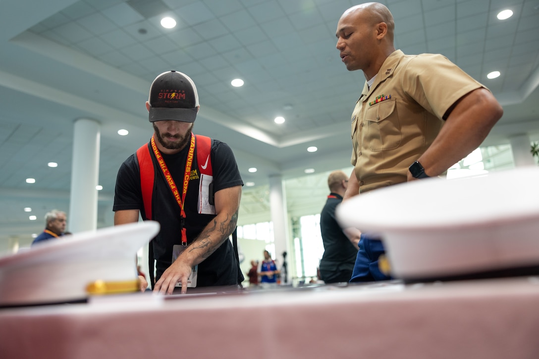 U.S. Marine Corps Capt. Terrence Zaleski, the marketing and communication officer for the 4th Marine Corps Recruiting District, and U.S. Marine Corps Capt. Wesley Williams, the officer selection officer for Recruiting Station Jacksonville, speaks to wrestling coaches about why wrestlers make great Marines during the National Wrestling Coaches Association Convention held in Ft. Lauderdale, Fla., on July 28, 2023. The partnership between NWCA and the Marine Corps aims to increase awareness of the Marine Corps among high school and college coaches, who are seen as key influencers in their communities, by engaging these influencers. The Marine Corps hopes to inspire more young people to consider a career in the Marine Corps and to promote the values of discipline, leadership and teamwork. (U.S. Marine Corps photo by Lance Cpl. Payton Goodrich)