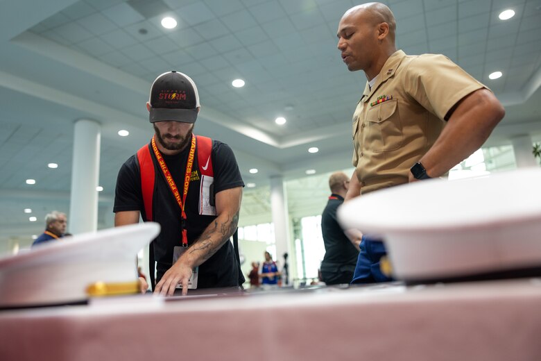 U.S. Marine Corps Capt. Terrence Zaleski, the marketing and communication officer for the 4th Marine Corps Recruiting District, and U.S. Marine Corps Capt. Wesley Williams, the officer selection officer for Recruiting Station Jacksonville, speaks to wrestling coaches about why wrestlers make great Marines during the National Wrestling Coaches Association Convention held in Ft. Lauderdale, Fla., on July 28, 2023. The partnership between NWCA and the Marine Corps aims to increase awareness of the Marine Corps among high school and college coaches, who are seen as key influencers in their communities, by engaging these influencers. The Marine Corps hopes to inspire more young people to consider a career in the Marine Corps and to promote the values of discipline, leadership and teamwork. (U.S. Marine Corps photo by Lance Cpl. Payton Goodrich)