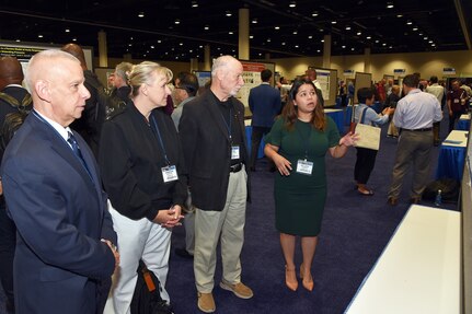 KISSIMMEE, Fla. – (Aug. 15, 2023) – Melissa Romero, of San Antonio, a researcher assigned to the Combat Casualty Care and Operational Medicine Directorate, Naval Medical Research Unit (NAMRU) San Antonio, briefs her research on the development of a translatable model of hemorrhagic shock and trauma associated sepsis to NAMRU San Antonio leadership during a poster session held on day two of the 2023 Military Health System Research Symposium (MHSRS) held at the Gaylord Palms Resort and Convention Center.  The MHSRS brings together military, government, academia, and industry experts for four days of critical conversations and intensive idea sharing. Presenters will share their latest research findings and challenges on topics including combat casualty care, military operational medicine, clinical and rehabilitative medicine, medical simulation and information sciences, military infectious diseases, and the radiation health effects. NAMRU San Antonio is one of the leading research and development laboratories for the U.S. Navy under the Department of Defense (DoD) and is one of eight subordinate research commands in the global network of laboratories operating under the Naval Medical Research Command in Silver Spring, Md.  Its mission is to conduct gap driven combat casualty care, craniofacial, and directed energy research to improve survival, operational readiness, and safety of DoD personnel engaged in routine and expeditionary operations. (U.S. Navy photo by Burrell Parmer, NAMRU San Antonio Public Affairs/Released)