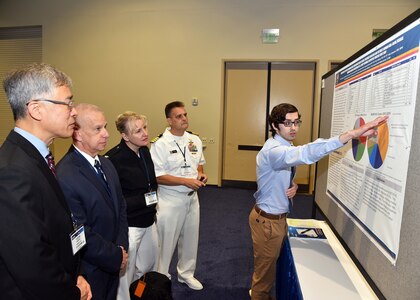 KISSIMMEE, Fla. – (Aug. 15, 2023) – Zachary McIntosh, a research scientist assigned to Craniofacial Health and Restorative Medicine Directorate, Naval Medical Research Unit (NAMRU) San Antonio, briefs her research titled “Comparison of the Most Common Dental Emergencies seen at Dental Treatment Facilities and the Most Common Oral-facial Disease requiring Medical Evacuation of U.S. Army Personnel in Deployed Theaters since 2000” to NAMRU San Antonio leadership during a poster session held on day two of the 2023 Military Health System Research Symposium (MHSRS) held at the Gaylord Palms Resort and Convention Center. The MHSRS brings together military, government, academia, and industry experts for four days of critical conversations and intensive idea sharing. Presenters will share their latest research findings and challenges on topics including combat casualty care, military operational medicine, clinical and rehabilitative medicine, medical simulation and information sciences, military infectious diseases, and the radiation health effects. NAMRU San Antonio is one of the leading research and development laboratories for the U.S. Navy under the Department of Defense (DoD) and is one of eight subordinate research commands in the global network of laboratories operating under the Naval Medical Research Command in Silver Spring, Md.  Its mission is to conduct gap driven combat casualty care, craniofacial, and directed energy research to improve survival, operational readiness, and safety of DoD personnel engaged in routine and expeditionary operations. (U.S. Navy photo by Burrell Parmer, NAMRU San Antonio Public Affairs/Released)
