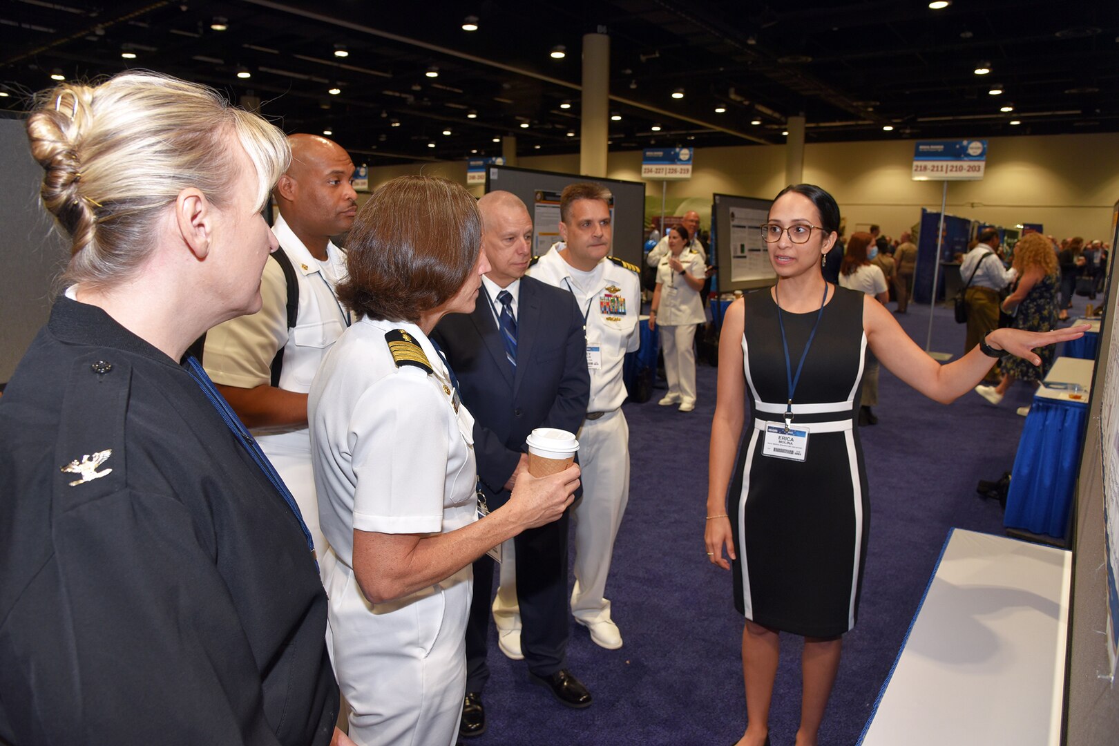 KISSIMMEE, Fla. – (Aug. 15, 2023) – Erica Molina, of San Antonio, a research scientist assigned to the Combat Casualty Care and Operational Medicine Directorate, Naval Medical Research Unit (NAMRU) San Antonio, briefs her research on the evaluation of a TNF-a inhibitor in mitigating acute kidney injury following REBOA intervention to Naval Medical Research Command and NAMRU San Antonio leadership during a poster session held on day two of the 2023 Military Health System Research Symposium (MHSRS) held at the Gaylord Palms Resort and Convention Center. The MHSRS brings together military, government, academia, and industry experts for four days of critical conversations and intensive idea sharing. Presenters will share their latest research findings and challenges on topics including combat casualty care, military operational medicine, clinical and rehabilitative medicine, medical simulation and information sciences, military infectious diseases, and the radiation health effects. NAMRU San Antonio is one of the leading research and development laboratories for the U.S. Navy under the Department of Defense (DoD) and is one of eight subordinate research commands in the global network of laboratories operating under the Naval Medical Research Command in Silver Spring, Md.  Its mission is to conduct gap driven combat casualty care, craniofacial, and directed energy research to improve survival, operational readiness, and safety of DoD personnel engaged in routine and expeditionary operations. (U.S. Navy photo by Burrell Parmer, NAMRU San Antonio Public Affairs/Released)