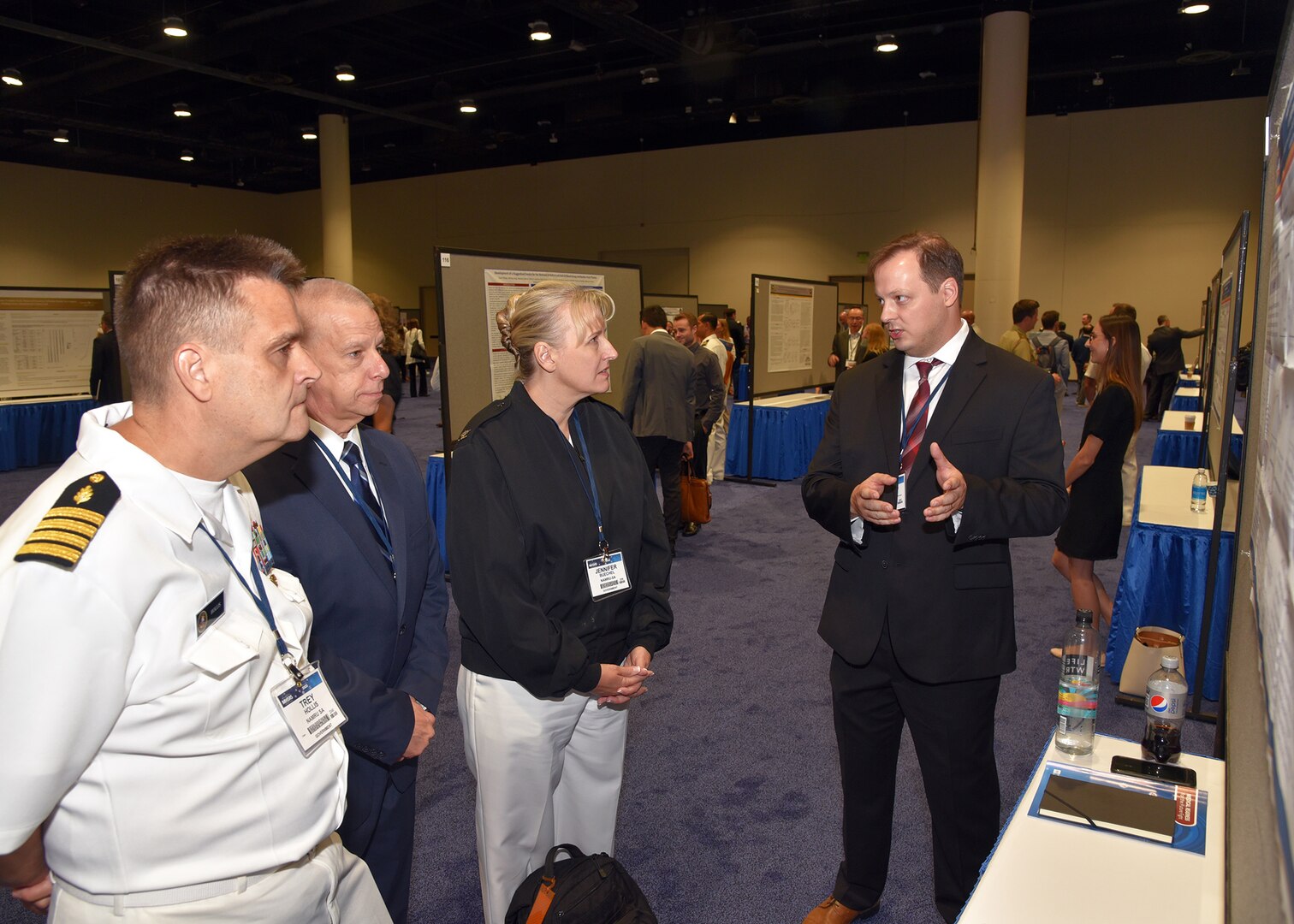 KISSIMMEE, Fla. – (Aug. 15, 2023) – Dr. Clifford Morgan, of Washington D.C., a research cell biologist, assigned to the Combat Casualty Care and Operational Medicine Directorate, Naval Medical Research Unit (NAMRU) San Antonio, presented his research on pre-hospital plasma is non-inferior to whole blood for restoration of cerebral oxygenation to NAMRU San Antonio leadership during a poster session held on day two of the 2023 Military Health System Research Symposium (MHSRS) held at the Gaylord Palms Resort and Convention Center. The MHSRS brings together military, government, academia, and industry experts for four days of critical conversations and intensive idea sharing. Presenters will share their latest research findings and challenges on topics including combat casualty care, military operational medicine, clinical and rehabilitative medicine, medical simulation and information sciences, military infectious diseases, and the radiation health effects. NAMRU San Antonio is one of the leading research and development laboratories for the U.S. Navy under the Department of Defense (DoD) and is one of eight subordinate research commands in the global network of laboratories operating under the Naval Medical Research Command in Silver Spring, Md.  Its mission is to conduct gap driven combat casualty care, craniofacial, and directed energy research to improve survival, operational readiness, and safety of DoD personnel engaged in routine and expeditionary operations. (U.S. Navy photo by Burrell Parmer, NAMRU San Antonio Public Affairs/Released)