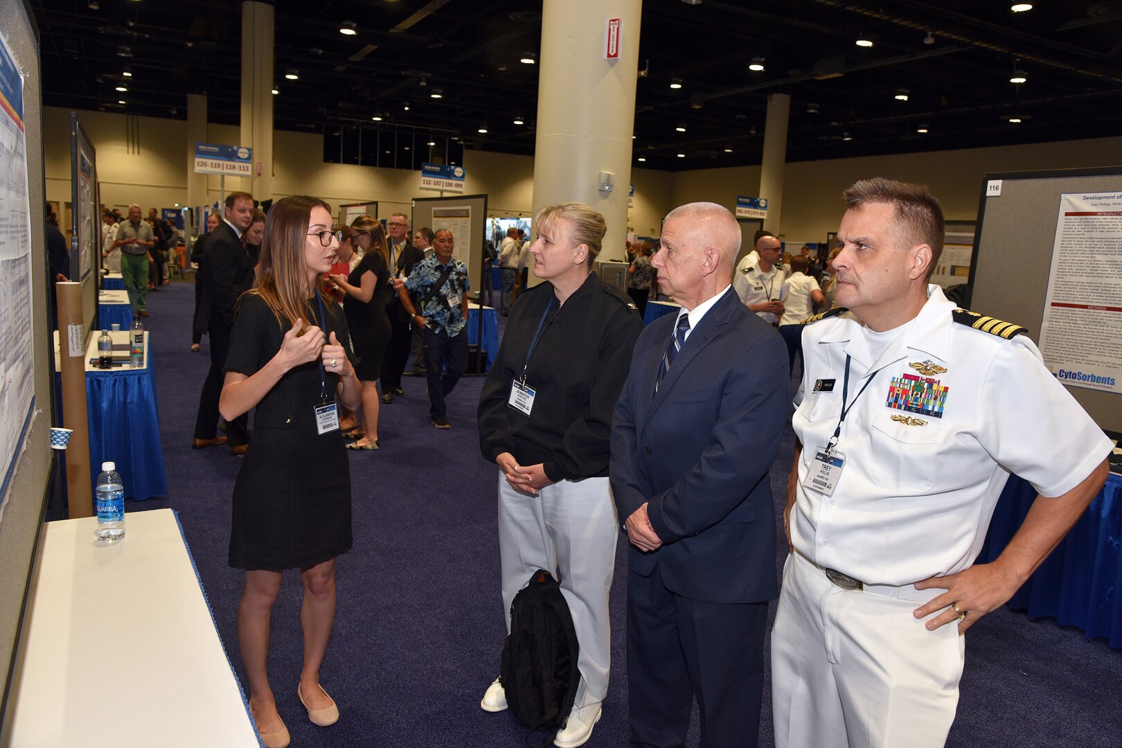 KISSIMMEE, Fla. – (Aug. 15, 2023) – Alejandra Lorenzen, a research scientist, assigned to the Combat Casualty Care and Operational Medicine Directorate, Naval Medical Research Unit (NAMRU) San Antonio, presented her research on solvent detergent frozen plasma to NAMRU San Antonio leadership during a poster session held on day two of the 2023 Military Health System Research Symposium (MHSRS) held at the Gaylord Palms Resort and Convention Center. The MHSRS brings together military, government, academia, and industry experts for four days of critical conversations and intensive idea sharing. Presenters will share their latest research findings and challenges on topics including combat casualty care, military operational medicine, clinical and rehabilitative medicine, medical simulation and information sciences, military infectious diseases, and the radiation health effects. NAMRU San Antonio is one of the leading research and development laboratories for the U.S. Navy under the Department of Defense (DoD) and is one of eight subordinate research commands in the global network of laboratories operating under the Naval Medical Research Command in Silver Spring, Md.  Its mission is to conduct gap driven combat casualty care, craniofacial, and directed energy research to improve survival, operational readiness, and safety of DoD personnel engaged in routine and expeditionary operations. (U.S. Navy photo by Burrell Parmer, NAMRU San Antonio Public Affairs/Released)
