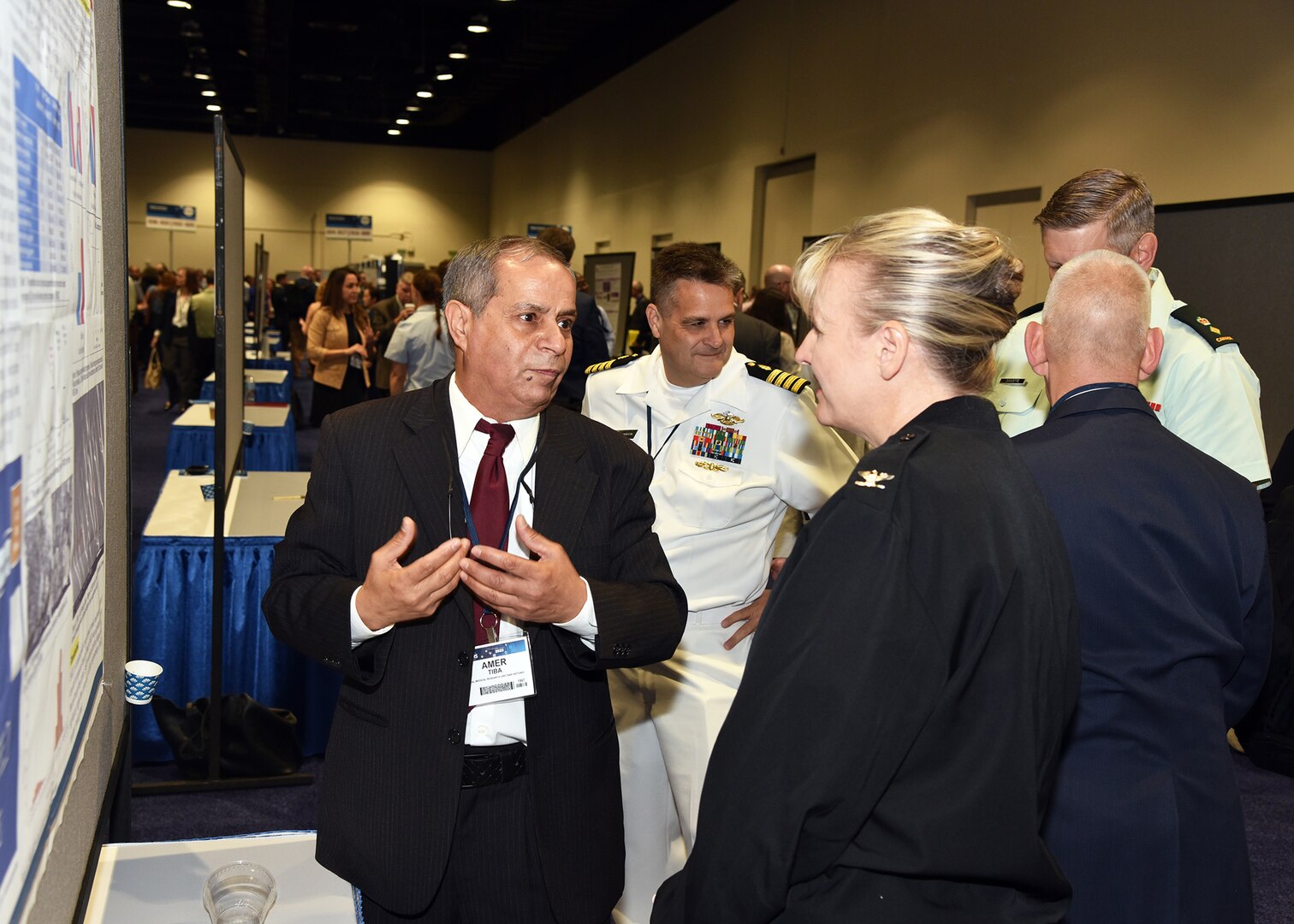 KISSIMMEE, Fla. – (Aug. 15, 2023) – Dr. Amer Tiba, a research scientist, assigned to Craniofacial Health and Restorative Medicine Directorate, Naval Medical Research Unit (NAMRU) San Antonio, briefs his research titled “Formulation of a Novel Self-healing Dental Resin and Testing its Performance” to NAMRU San Antonio leadership during a poster session held on day two of the 2023 Military Health System Research Symposium (MHSRS) held at the Gaylord Palms Resort and Convention Center. The MHSRS brings together military, government, academia, and industry experts for four days of critical conversations and intensive idea sharing. Presenters will share their latest research findings and challenges on topics including combat casualty care, military operational medicine, clinical and rehabilitative medicine, medical simulation and information sciences, military infectious diseases, and the radiation health effects. NAMRU San Antonio is one of the leading research and development laboratories for the U.S. Navy under the Department of Defense (DoD) and is one of eight subordinate research commands in the global network of laboratories operating under the Naval Medical Research Command in Silver Spring, Md.  Its mission is to conduct gap driven combat casualty care, craniofacial, and directed energy research to improve survival, operational readiness, and safety of DoD personnel engaged in routine and expeditionary operations. (U.S. Navy photo by Burrell Parmer, NAMRU San Antonio Public Affairs/Released)