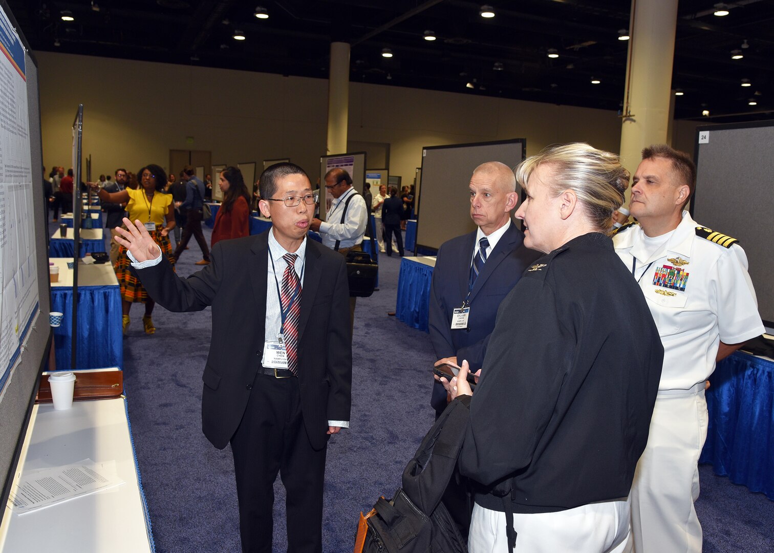KISSIMMEE, Fla. – (Aug. 15, 2023) – Dr. Wen Chen, of San Antonio, a research scientist, assigned to Craniofacial Health and Restorative Medicine Directorate, Naval Medical Research Unit (NAMRU) San Antonio, briefs his research titled “Analytical Characterization of an Encapsulated-based, Self-healing Dental Composite System using Liquid Chromatography with Tandem Mass” to NAMRU San Antonio leadership during a poster session held on day two of the 2023 Military Health System Research Symposium (MHSRS) held at the Gaylord Palms Resort and Convention Center. The MHSRS brings together military, government, academia, and industry experts for four days of critical conversations and intensive idea sharing. Presenters will share their latest research findings and challenges on topics including combat casualty care, military operational medicine, clinical and rehabilitative medicine, medical simulation and information sciences, military infectious diseases, and the radiation health effects. NAMRU San Antonio is one of the leading research and development laboratories for the U.S. Navy under the Department of Defense (DoD) and is one of eight subordinate research commands in the global network of laboratories operating under the Naval Medical Research Command in Silver Spring, Md.  Its mission is to conduct gap driven combat casualty care, craniofacial, and directed energy research to improve survival, operational readiness, and safety of DoD personnel engaged in routine and expeditionary operations. (U.S. Navy photo by Burrell Parmer, NAMRU San Antonio Public Affairs/Released)