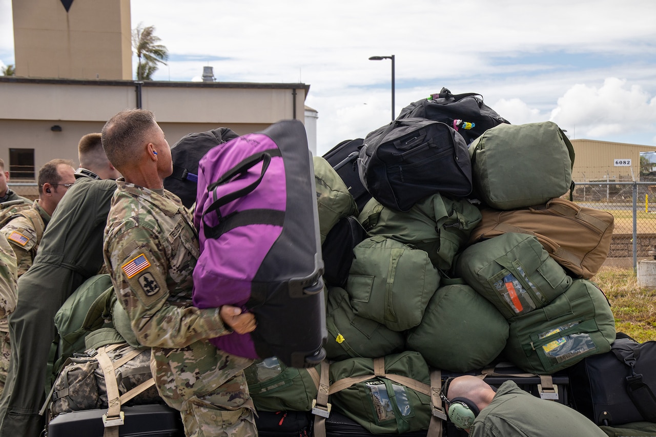 Service members load cargo onto a military aircraft.