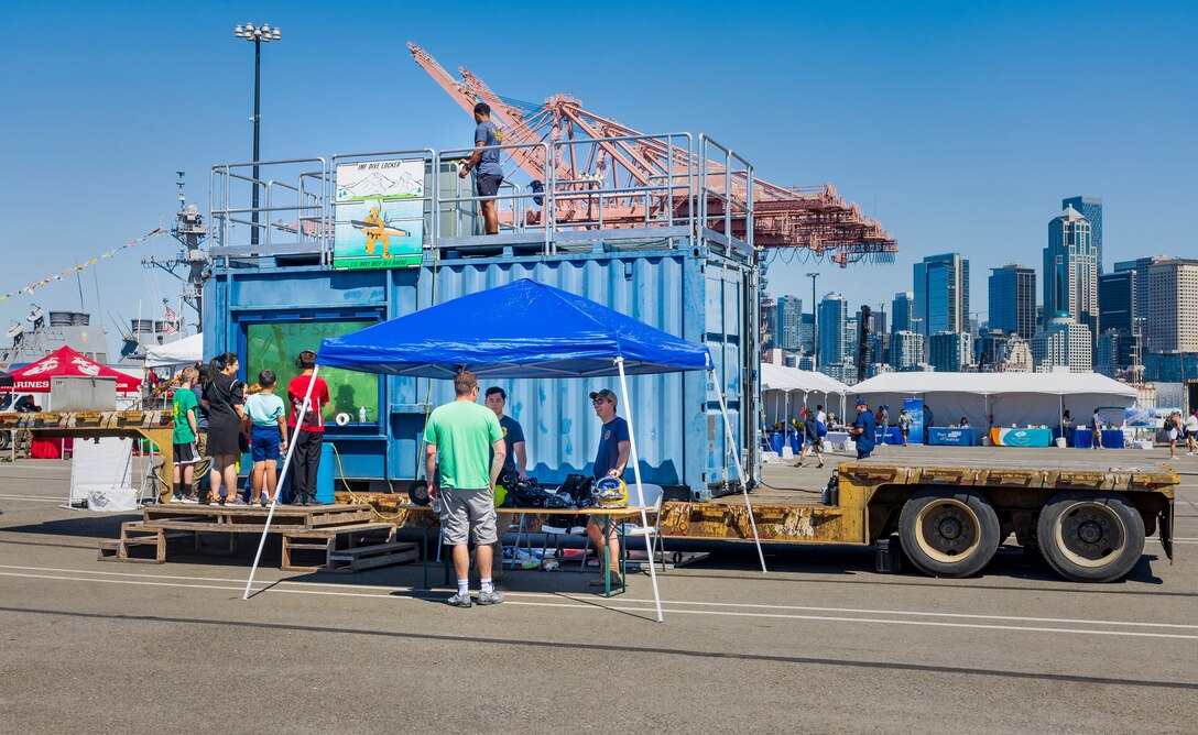 U.S. Navy divers from the Bangor, Keyport and Everett dive lockers participated in the annual Seafair celebration Aug. 3, 2023, on Pier 46 in Seattle. Divers answered questions and played "tic tac toe" with visitors from inside a dive tank. (U.S. Navy photo by Wendy Hallmark)