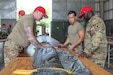 Staff Sgt. Robert Swann, 824th Quartermaster Company, conducts refresher training on proper packing of an MC-6 personnel parachute during Exercise Northern Strike at the Alpena Combat Readiness Training Center, Michigan, Aug. 7, 2023. Sgt. Joshua Brackin and Specialists Benny Do and Samuel Odero participated in the training. Exercise Northern Strike 2023 is a premier reserve component training event that integrates both U.S. and partner nation readiness training to build interoperability and strengthen partnerships in an all-domain environment. (U.S. Air National Guard photo by Senior Master Sgt. Dan Heaton)