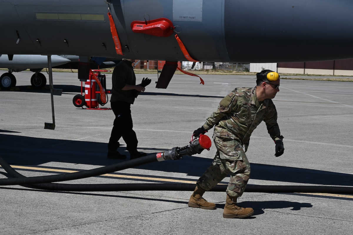 U.S. Air National Guard Staff Sgt. Joel Camacho, fuels distribution operator from the 175th Logistics Readiness Squadron, moves a hose on the flightline at Joint Base Pearl Harbor-Hickam, June 21, 2023.