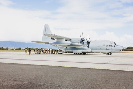 Marines board a military aircraft.