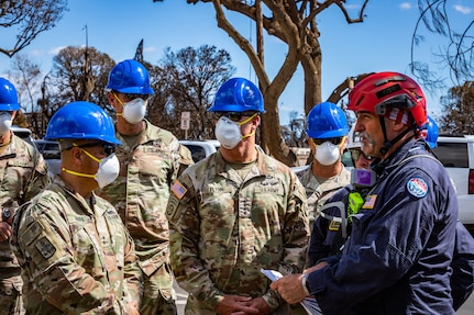 Soldiers speak with local search, rescue and recovery personnel after wildfires in Maui, Hawaii.