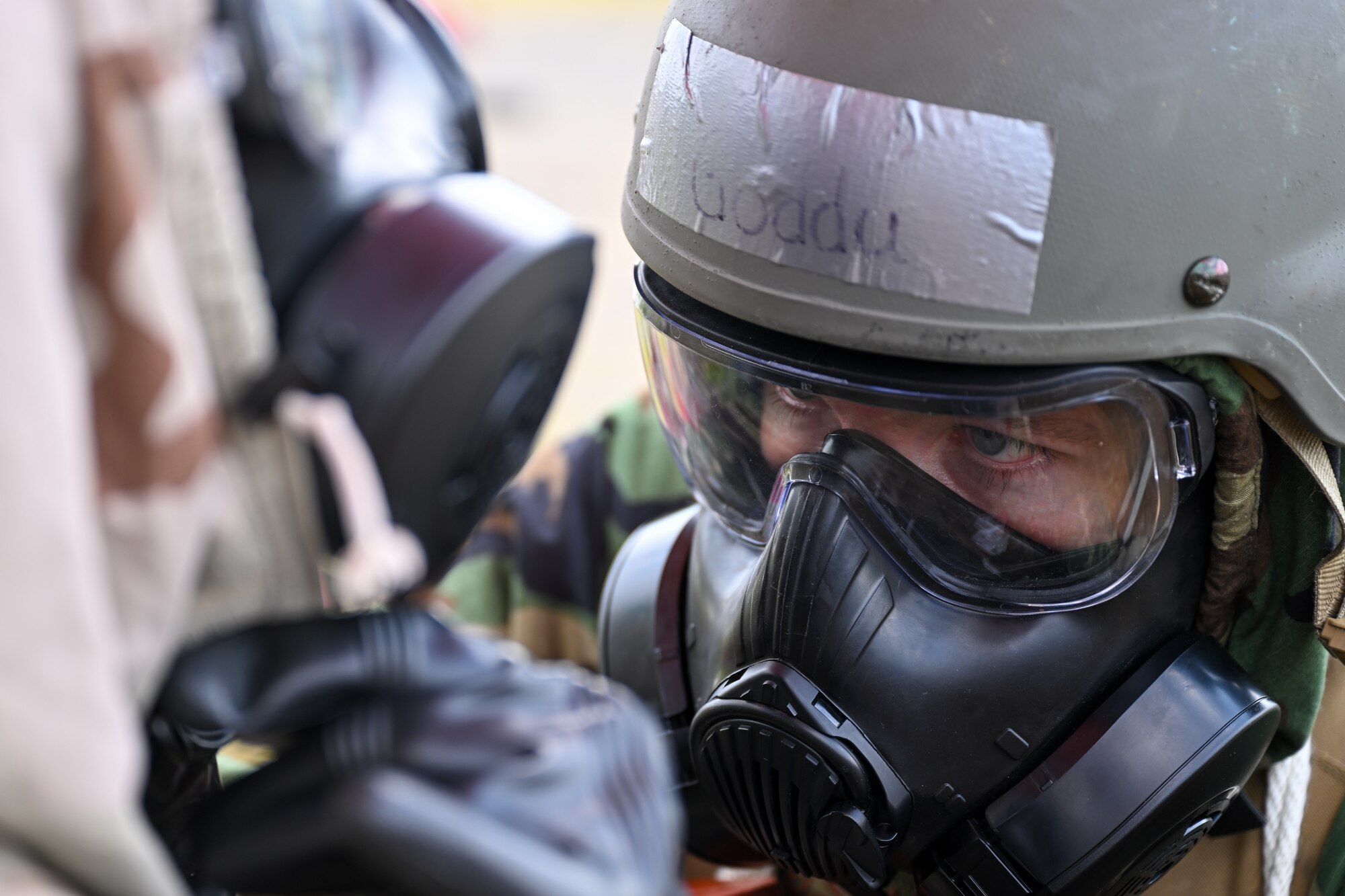 Staff Sgt. Brent Goddu, an Airman assigned to the 99th Medical Support Squadron at Nellis Air Force Base, Nevada, assists a fellow medic in adjusting a gas mask during a simulated chemical attack as part of Exercise Patriot Medic at Youngstown Air Reserve Station, Ohio, Aug. 16, 2023.