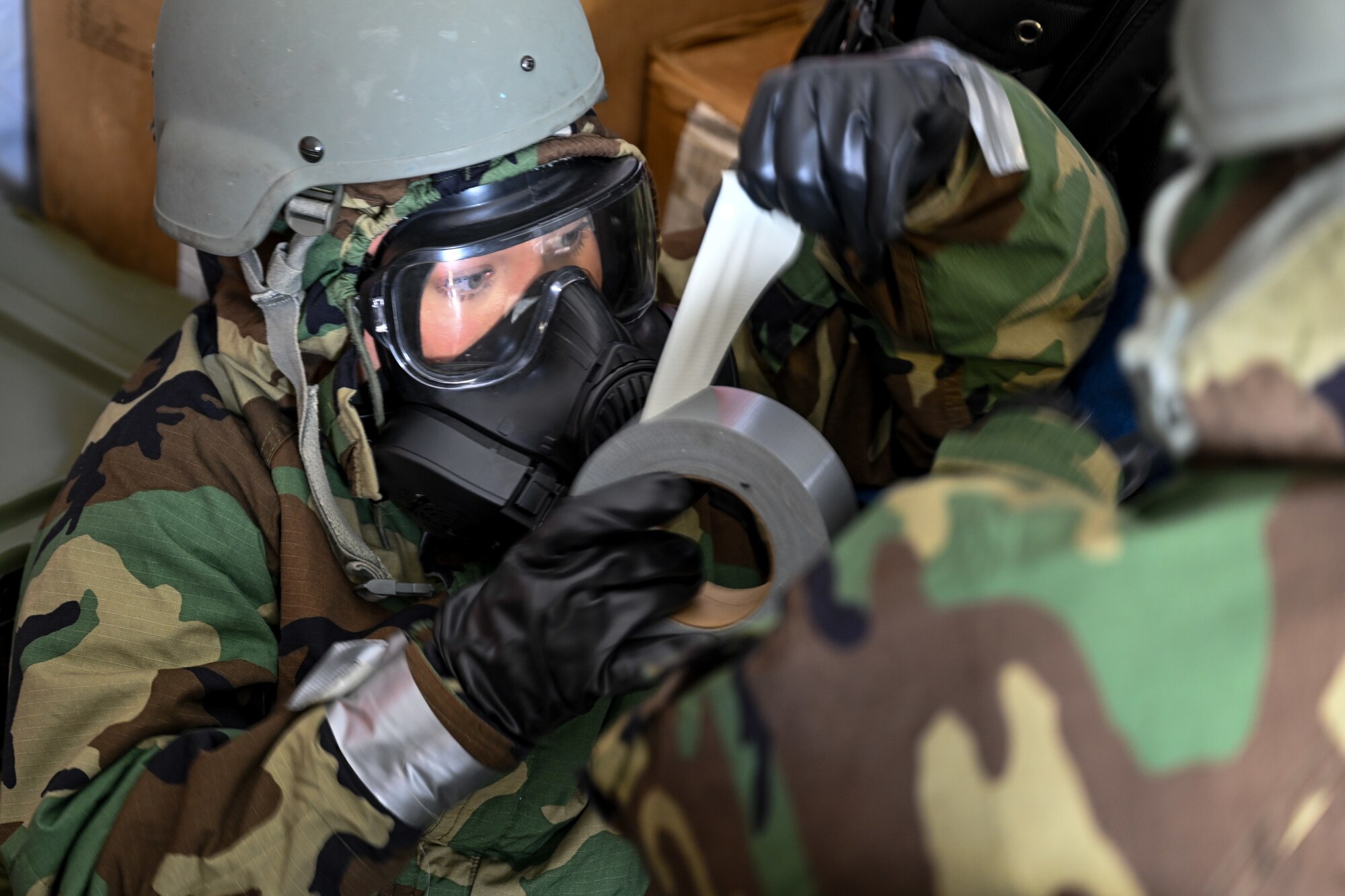 An Air Force Reserve medic assists a wingman in donning and securing MOPP gear while responding to a simulated chemical attack as part of Exercise Patriot Medic at Youngstown Air Reserve Station, Ohio, Aug.