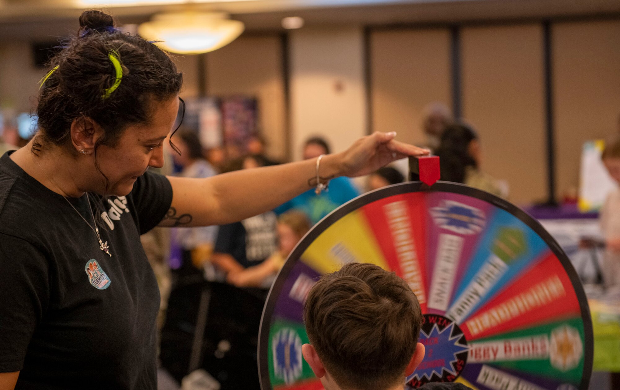 A mother and a child spin a colorful wheel.