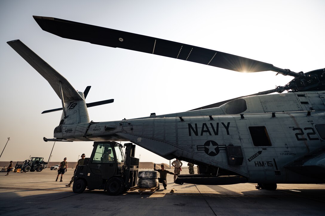 Photo of person loading cargo onto an aircraft