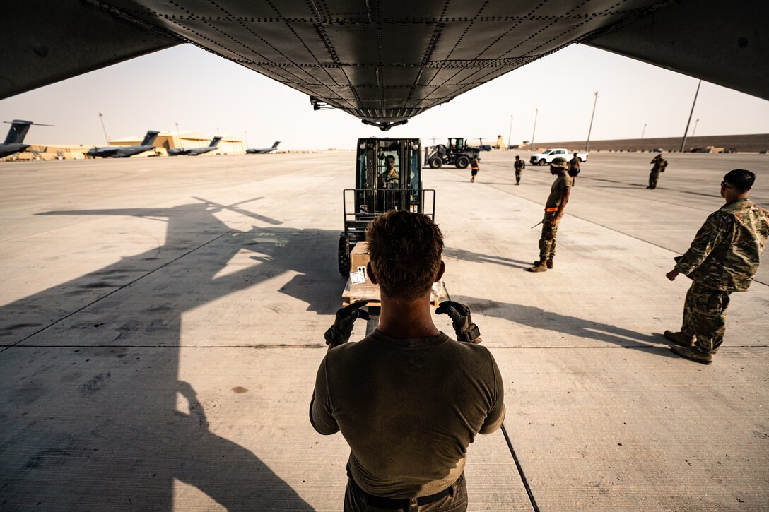 Photo of person loading cargo onto an aircraft