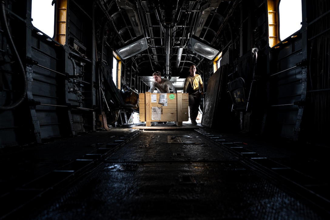 Photo of person loading cargo onto an aircraft