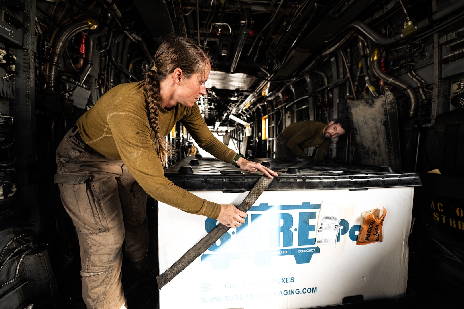 Photo of person loading cargo onto an aircraft