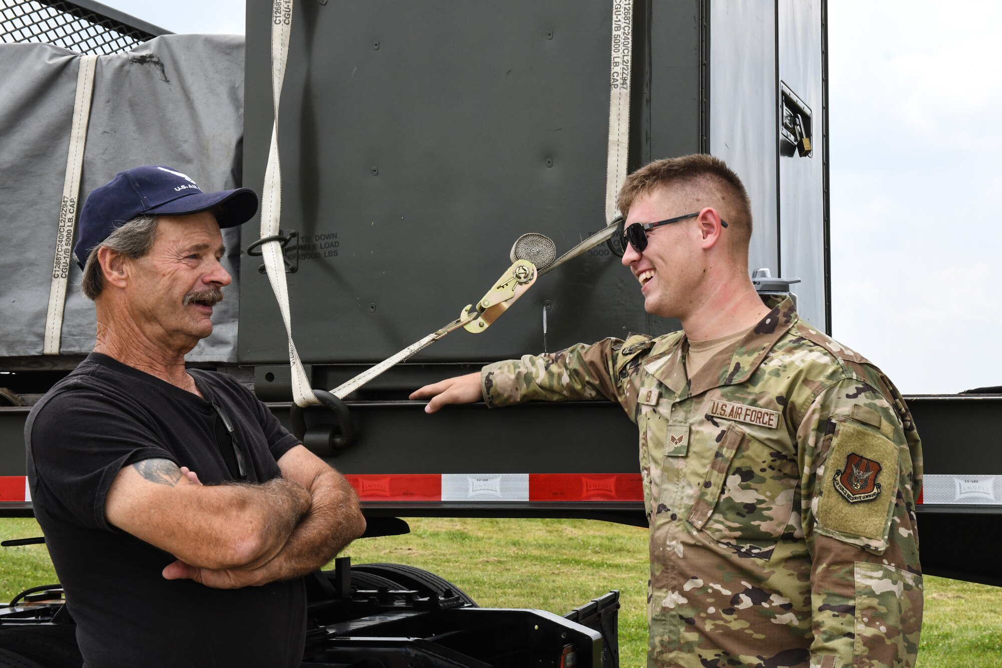 Senior Airman Dylan Miller, an aerial spray technician assigned to the 757th Airlift Squadron, talks with event guest, Aug. 6, 2023, at the Wings and Wheels Fly-In and Car Show at Youngstown-Warren Regional Airport, Ohio.