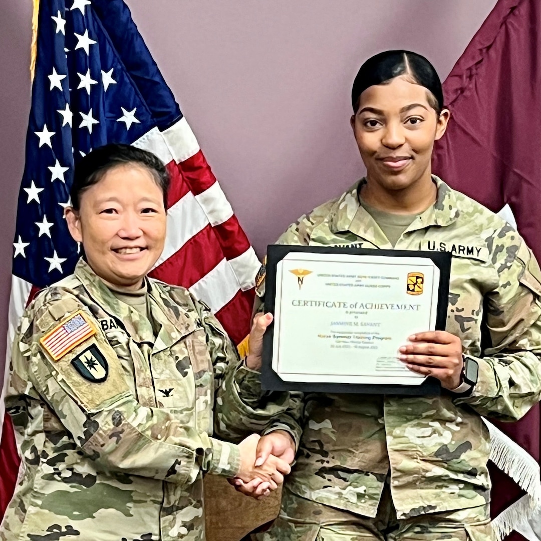 Deputy Commander poses with Nursing student while displaying certificate.