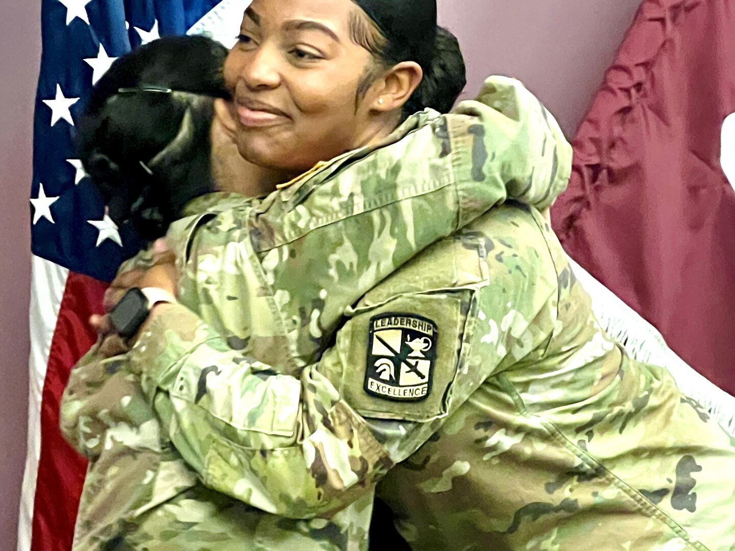 Deputy Commander congratulating nursing student with a hug.