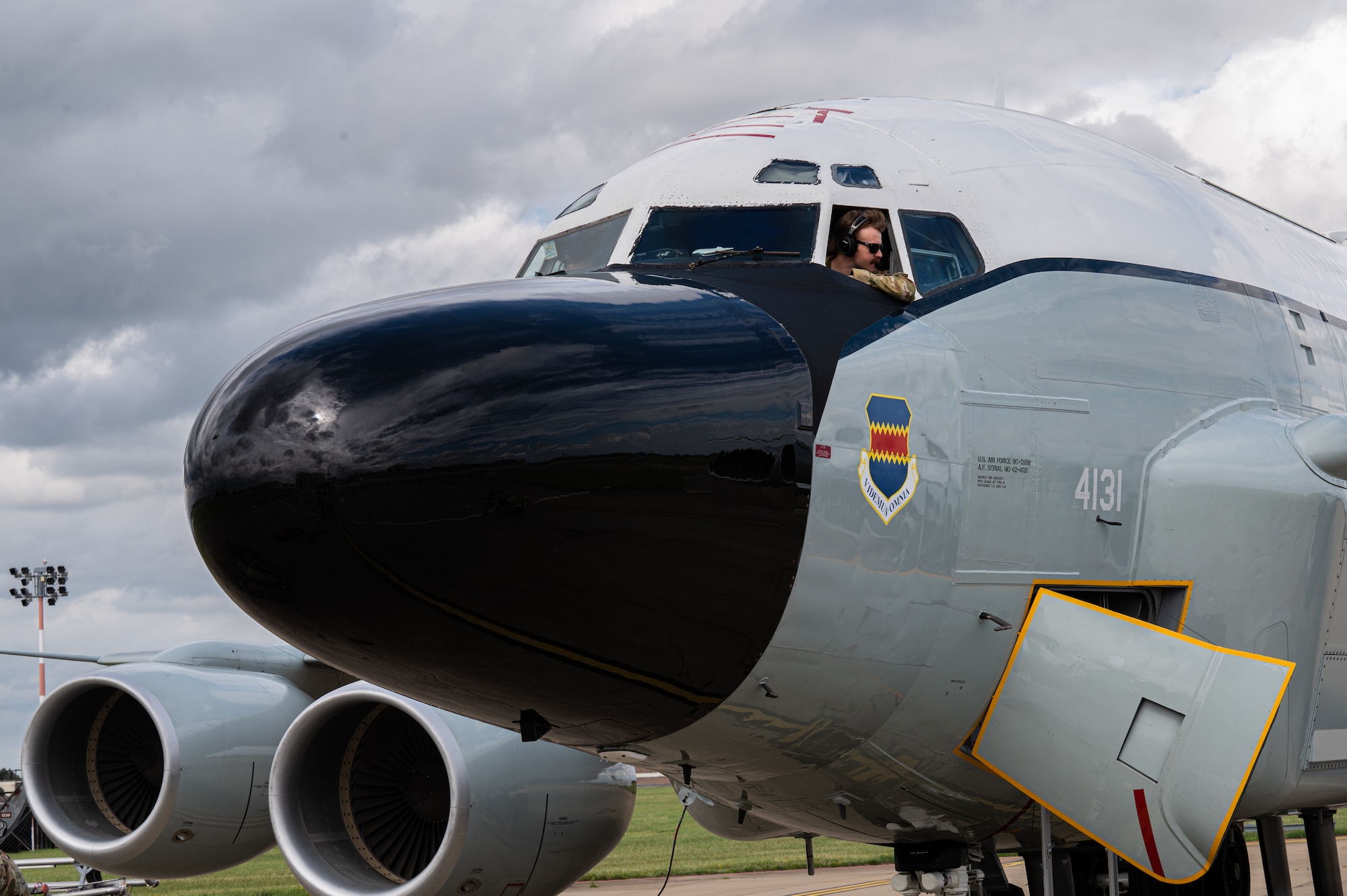 U.S. Air Force Capt. Max Burnworth, 38th Reconnaissance Squadron RC-135 Rivet Joint aircraft pilot, surveys the surrounding area on the flightline during the airframe’s first hot-pit refueling at Royal Air Force Mildenhall, England, Aug. 14, 2023.