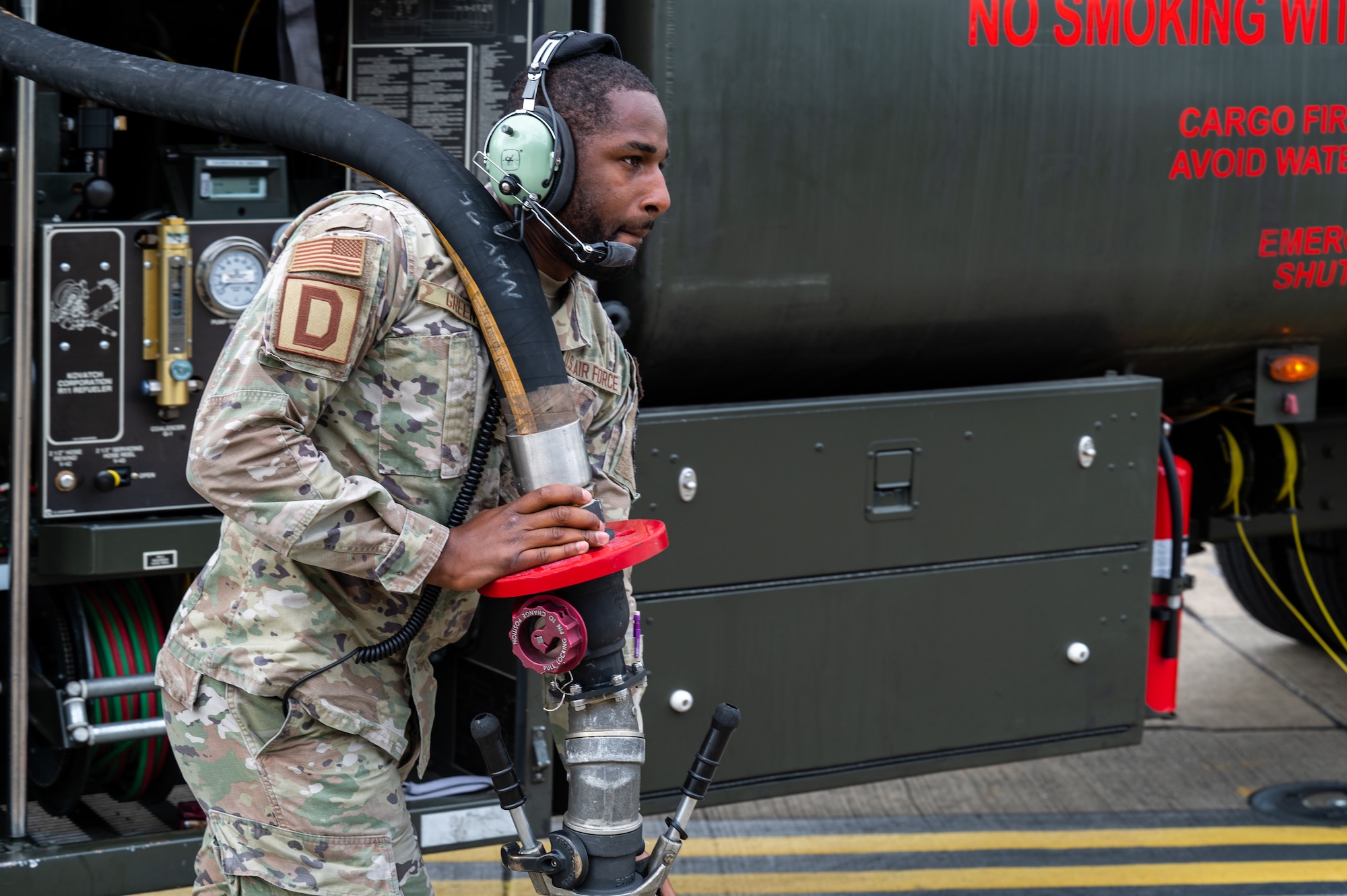U.S. Air Force Airman 1st Class Jo’von Green, 100th Logistics Readiness Squadron fuels distribution operator, carries a fuel hose to a RC-135 Rivet Joint aircraft on the flightline at Royal Air Force Mildenhall, England, Aug. 14, 2023.