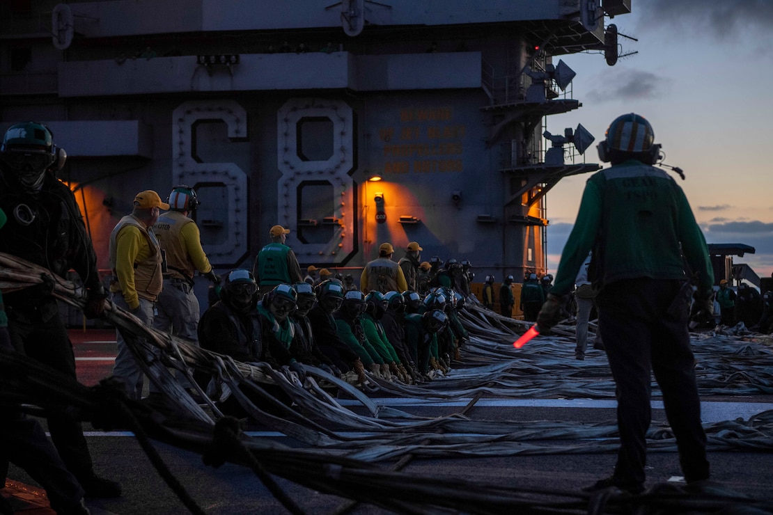 Sailors rig the barricade in a flight deck drill on aircraft carrier USS Nimitz (CVN 68). Nimitz is currently underway conducting routine operations.