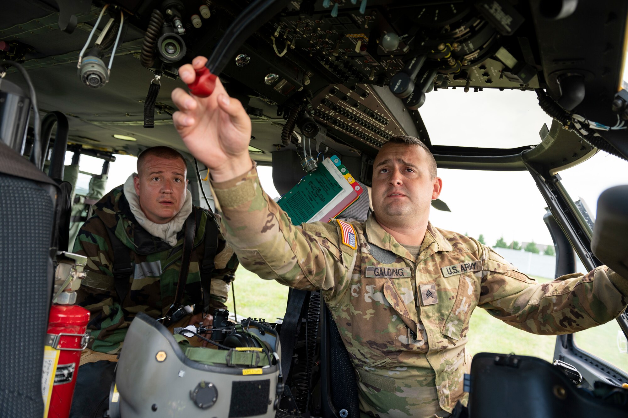 U.S. Army Sgt. Cordell Gaulding, a crew chief from C Company, 1st Battalion, 150th Aviation Regiment, shows emergency shutdown procedures to U.S. Air Force Staff Sgt. Timothy Sanders, a firefighter with the 167th Airlift Wing, during a UH-60M Black Hawk helicopter crash landing incident response as part of a readiness exercise at the 167th Airlift Wing, Martinsburg, West Virginia, Aug, 12, 2023.