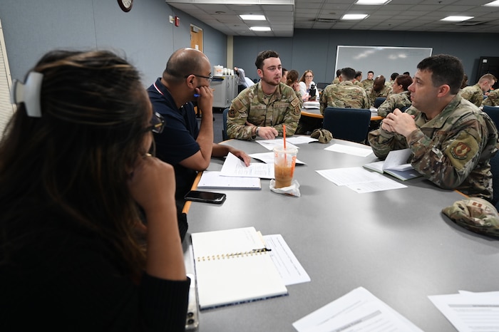 image of people sitting around a desk talking.