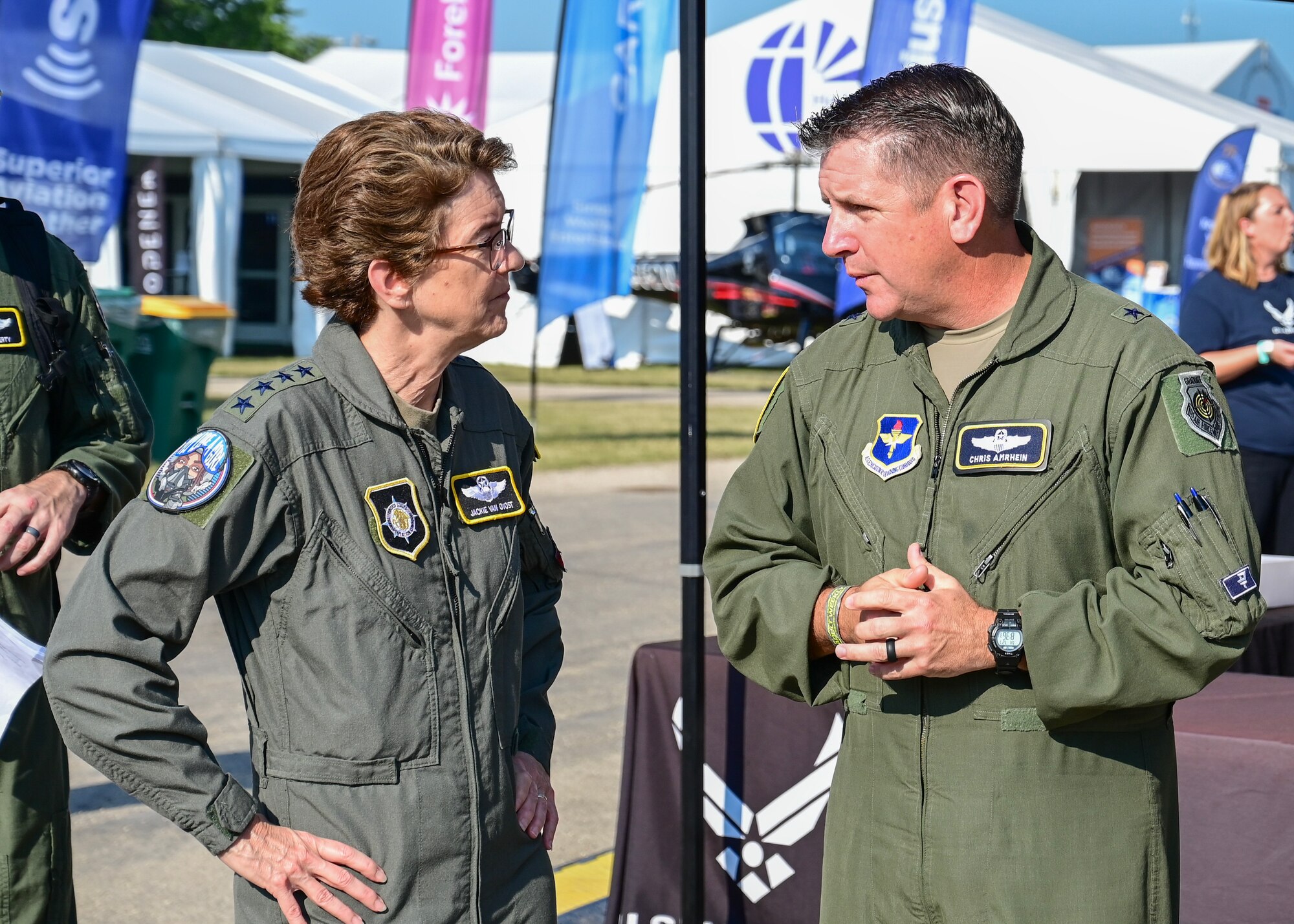 Gen. Jacqueline D. Van Ovost, commander of U.S. Transportation Command, speaks with Brig. Gen. Christopher Amrhein, Air Force Recruiting Service commander, during EAA AirVenture Oshkosh, in Oshkosh, WI, July 27, 2023.