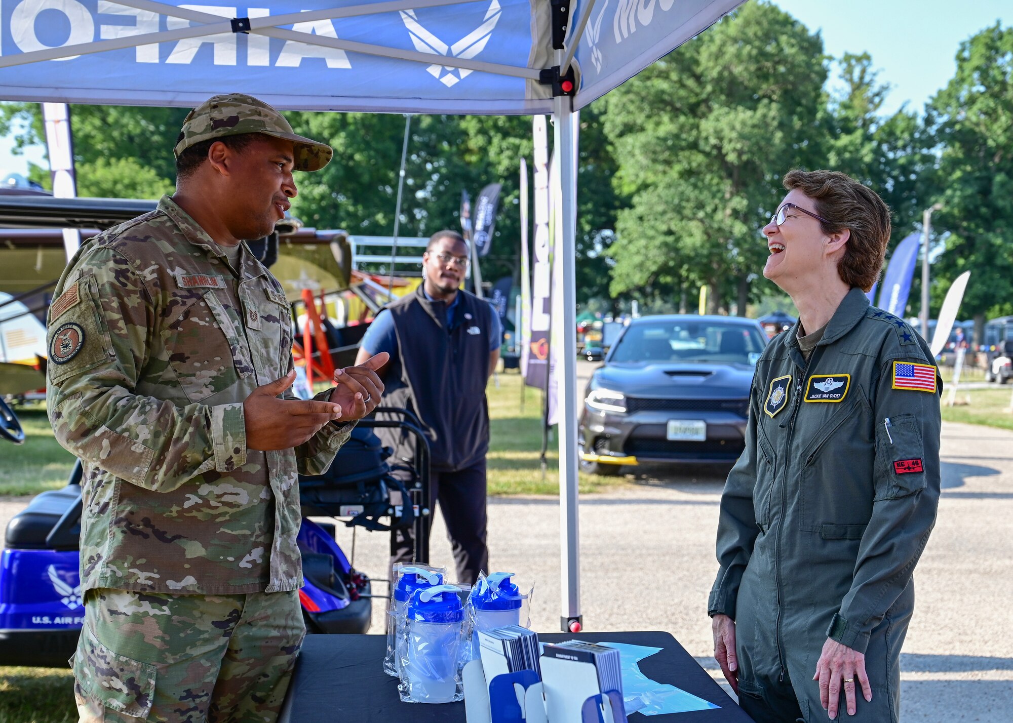 Gen. Jacqueline D. Van Ovost, commander of U.S. Transportation Command, speaks with Tech. Sgt. Demarcus Shanklin, Air Force Recruiting Service events marketer, during EAA AirVenture Oshkosh, in Oshkosh, WI, July 27, 2023.