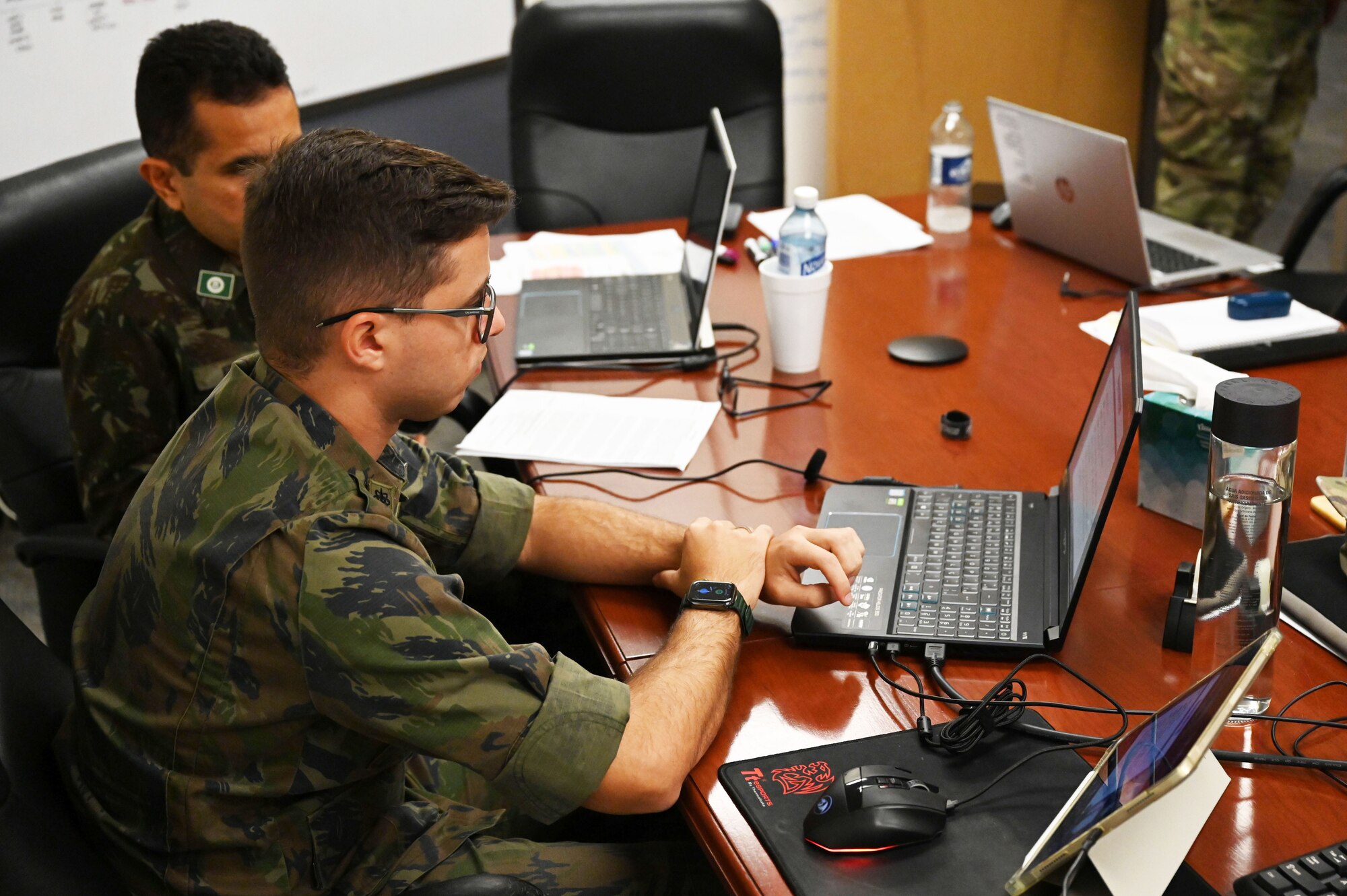 Two of the brazilian military members involved in BOLT 5 of Vulcan guard look through data on laptop.