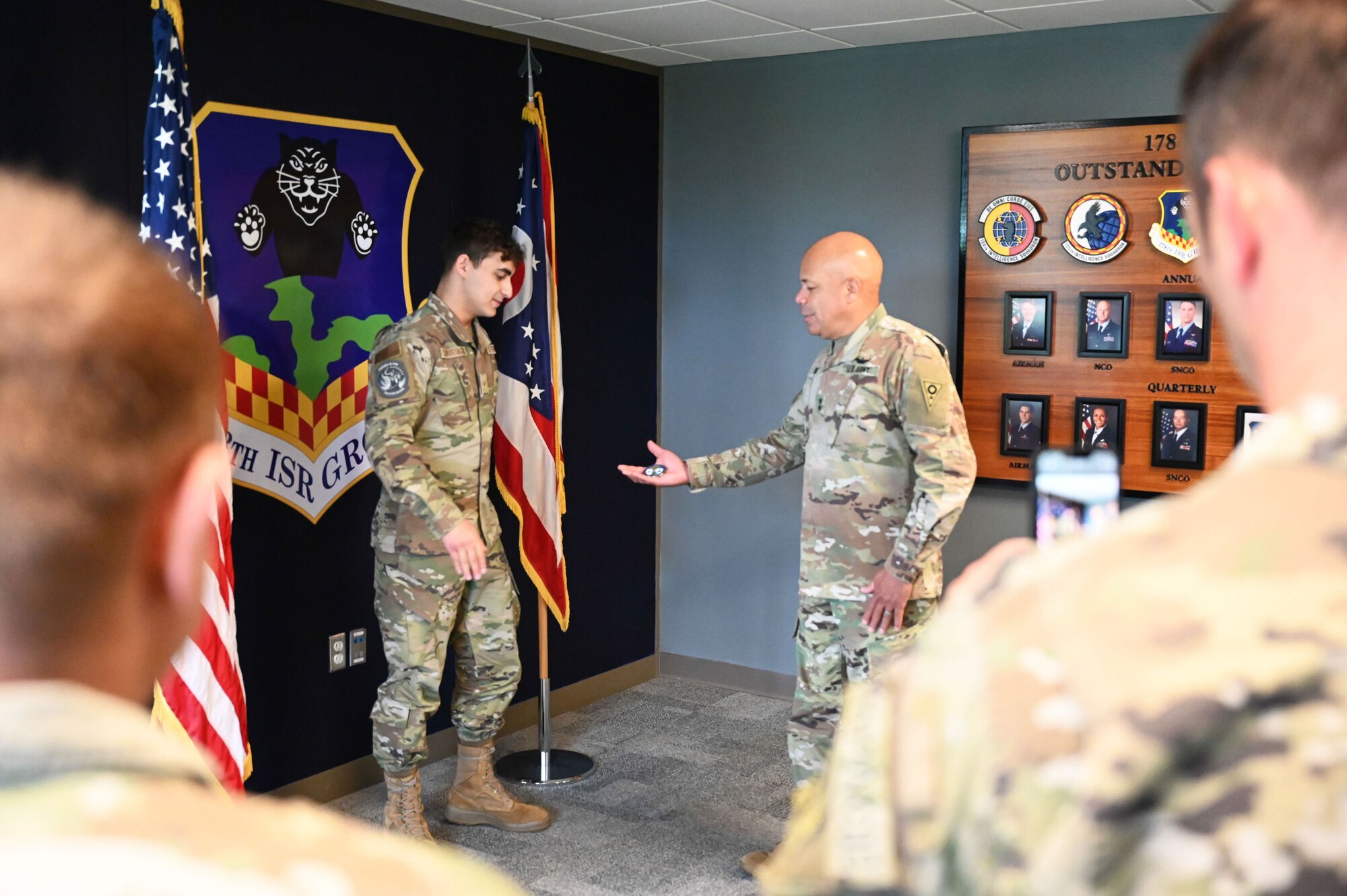 Major General Harris coins Senior Airmen Capostagno.