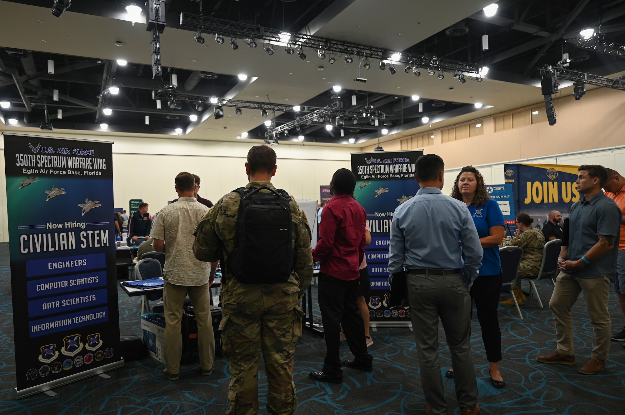 Civilian personnel program specialists from the 350th Spectrum Warfare Wing talk to numerous job seekers during a career summit at Fort Walton Beach, Fla., Aug. 17, 2023. Currently the wing has about 200 engineer vacancies. (U.S. Air Force photo by Staff Sgt. Ericka A. Woolever)