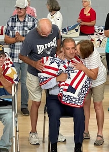 Chief Master Sgt. Kelly Luzum, OSI Region 3's leading enlisted Special Agent, was recognized for his military service by his hometown of Calmer, Iowa, with a quilt handcrafted by two fellow Iowans—both a tribute to his career and a reminder that the community cherishes its own.