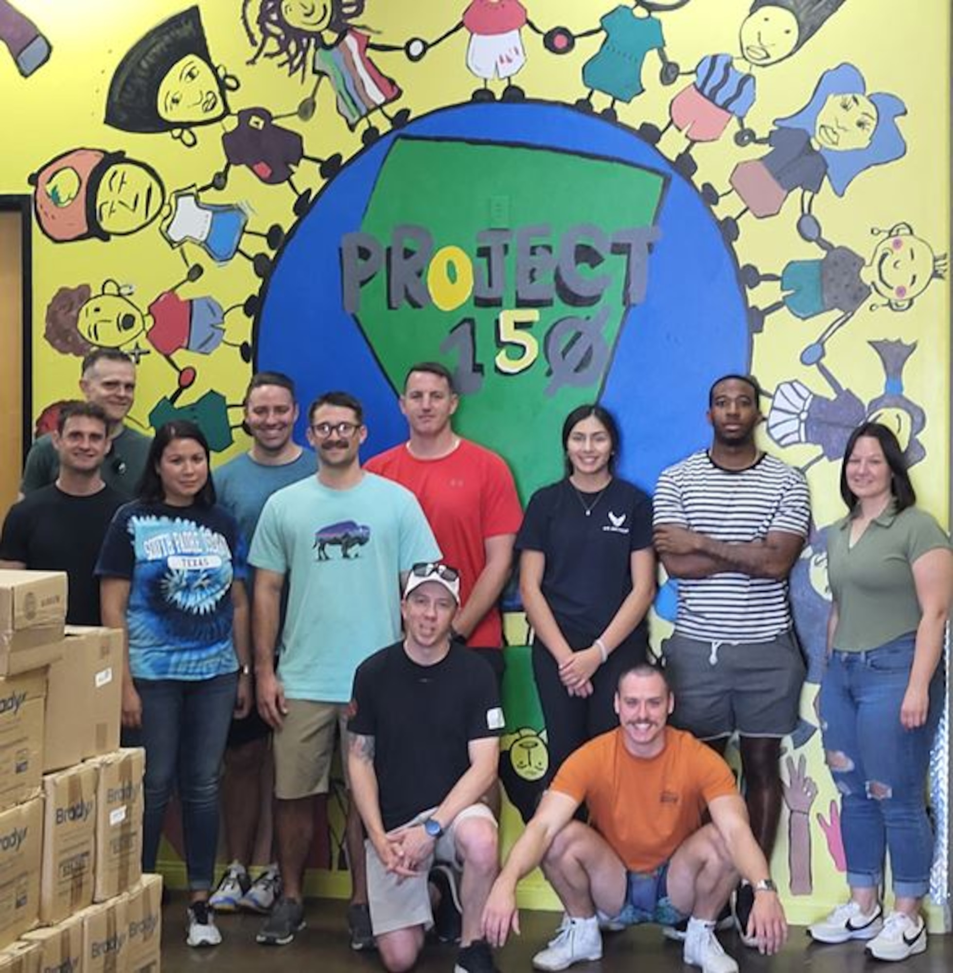 Airmen pose for a photo at Project 150 after packing school supplies.