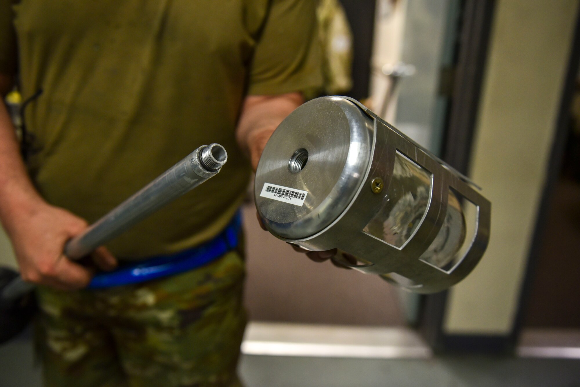Tech Sgt. Eric Kozma, 92nd Maintenance Squadron metal technology noncommissioned officer in charge, demonstrates a prototype he designed for collecting fuel samples from a K-135 Stratotanker at Fairchild Air Force Base, Washington, July 24, 2023. Kozma designed the prototype to improve safety for Airmen on the flight line, allowing them to get a fuel sample without climbing a ladder and reducing the risk of fuel spills. (U.S. Air Force photo by Airman 1st Class Lillian Patterson)