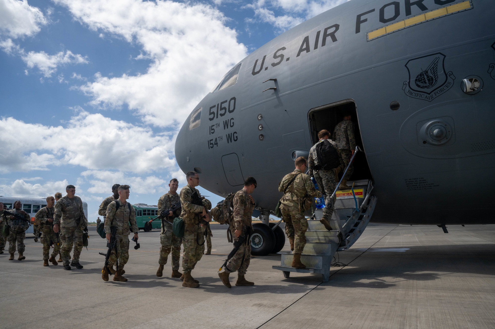 U.S. Army soldiers assigned to the 25th Infantry Division board a C-17 Globemaster III during Exercise Mungadai at Joint Base Pearl Harbor-Hickam, Hawaii, August 1, 2023. Team Hickam Airmen loaded cargo, including a U.S. Army M119A3 105 MM Light Towed Howitzer and a U.S. Army High Mobility Multipurpose Wheeled Vehicle, a U.S. Army OshKosh - Mine Resistant Ambush Protected Vehicle all-terrain vehicle in support of Exercise Mungadai. (U.S. Air Force photo by Senior Airman Makensie Cooper)