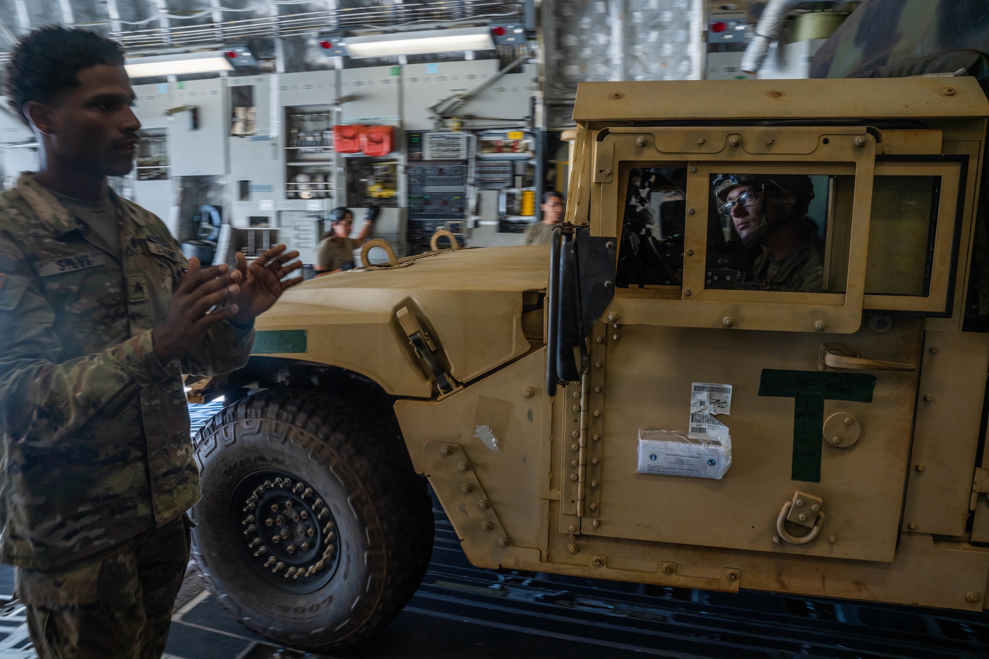 Spc. Nathan Schmitz, 25th Infantry Division 211th battalion cannon crew member, drives a Humvee on a C-17 Globemaster III during a cargo load in support of Exercise Mungadai at Joint Base Pearl Harbor-Hickam, Hawaii, August 1, 2023. Team Hickam Airmen provided airlift capabilities to over 50 U.S. Army soldiers in support of Exercise Mungadai, a week long field artillery exercise. (U.S. Air Force photo by Senior Airman Makensie Cooper)