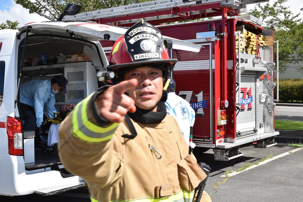 A firefighter participating in Exercise Mamoru attempts to get colleagues' attention