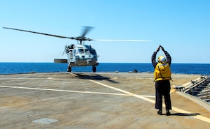 230812-N-JC445-1011 ADRIATIC SEA (August 12, 2023) Able Seaman Daries Smith, a Military Sealift Command (MSC) civilian mariner, directs a MH-60S Sea Hawk Helicopter attached to the “Ghost Riders” of Helicopter Sea Combat Squadron (HSC) 28, during flight operations from the Blue Ridge-class command and control ship USS Mount Whitney (LCC 20), the flagship of U.S. 6th Fleet. Mount Whitney is participating in Large Scale Exercise 2023 from Aug. 9-18, which is a live, virtual, and constructive, globally-integrated exercise designed to refine the synchronization of maritime operations across six maritime component commands, seven numbered fleets, and 22 time zones. (U.S. Navy photo by Mass Communication Specialist 2nd Class Mario Coto)
